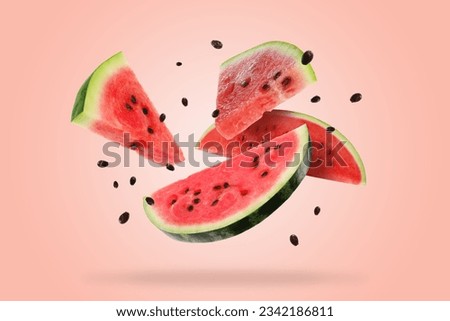 Slices of fresh juicy watermelon falling on pink background Royalty-Free Stock Photo #2342186811