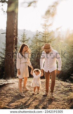 Young happy family chilling in sunny mountains 