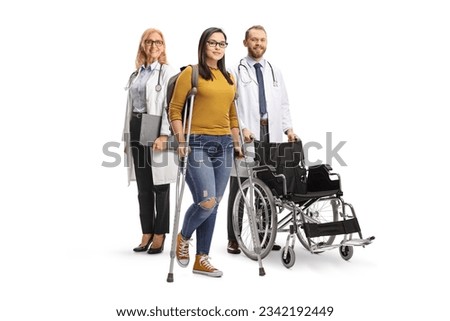 Injured young female with crutches and a medical team with a wheelchair isolated on white background Royalty-Free Stock Photo #2342192449