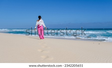 Asian women relaxing on the beach at De Hoop Nature Reserve South Africa Western Cape, the most beautiful beach in South Africa with the white dunes part of the garden route.  Royalty-Free Stock Photo #2342205651