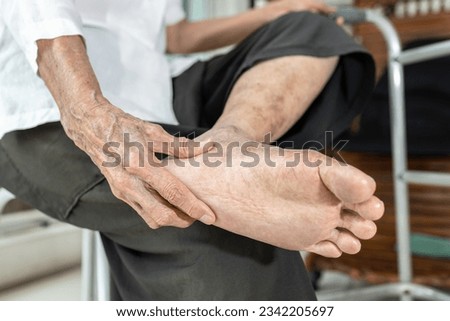 Elderly woman massage her foot,Plantar fasciitis,pain in soles of foot and heel bone,Tarsal tunnel syndrome,compression of a nerve in foot or Achilles tendonitis,inflammation of tendon at back of heel Royalty-Free Stock Photo #2342205697