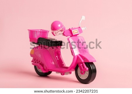Pink vintage toy doll scooter or motorbike with helmet on pastel pink background. 80s, clsssic, retro style Royalty-Free Stock Photo #2342207231