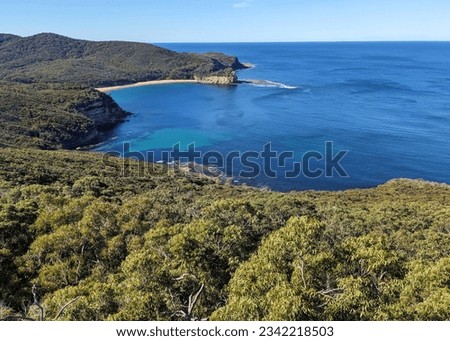 View of Maitland Bay in Bouddi National Park on the Central Coast of New South Wales, Australia. View of a wild, blue ocean bay, surrounded by eucalyptus forests. Royalty-Free Stock Photo #2342218503