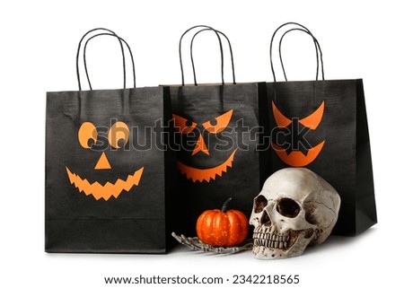 Black shopping bags, skull, skeleton hand and pumpkin for Halloween on white background