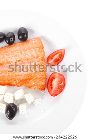 red salmon fish big fillet chunk roast and served on plate with greek white cheese black olives and tomatoes isolated over white background