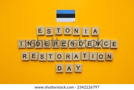 August 20, Estonia Independence Restoration Day, flag of Estonia, minimalistic banner with the inscription in wooden letters on an orange background
