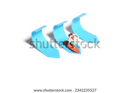 Creative miniature people toy figure photography. Sticky notes installation. A girl surfer riding big waves on surfing board. Isolated on white background. Image photo