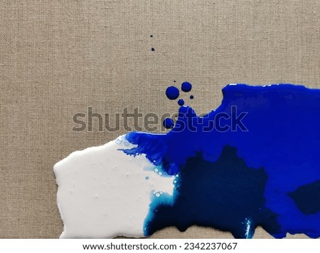 Navy blue and white paint spilled on linen canvas, blot
