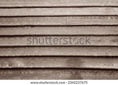 a photography of a wooden wall with a small window, wood planks with a small hole in the middle.