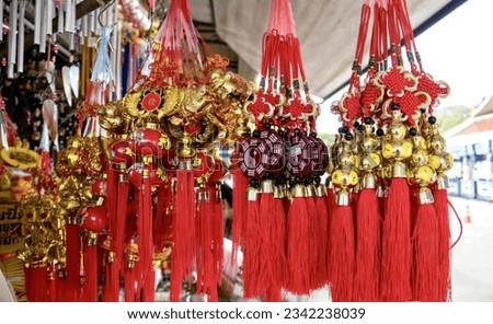 a photography of a bunch of red and gold ornaments hanging from a ceiling, a close up of a bunch of red and gold ornaments.