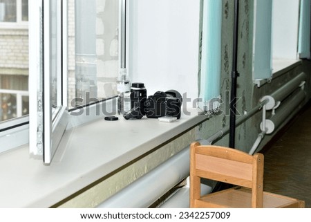 The photographer left the camera and lens on the wide window sill.