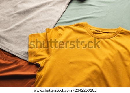 Close up of flat lay of multi coloured t shirts and copy space background. Fashion, clothes, colour and fabric concept.