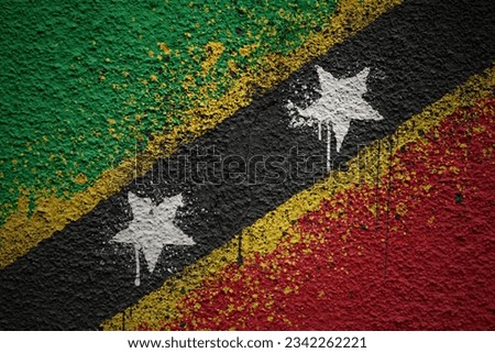 colorful painted big national flag of saint kitts and nevis on a massive old cracked wall