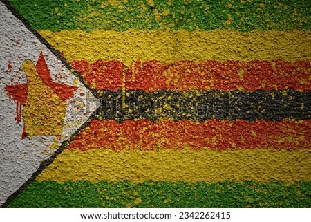 colorful painted big national flag of zimbabwe on a massive old cracked wall