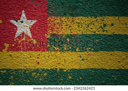 colorful painted big national flag of togo on a massive old cracked wall