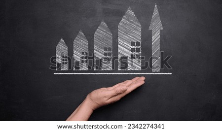 Chalk drawn houses and up arrow. the concept of rising real estate prices. High rent, higher mortgage rates Royalty-Free Stock Photo #2342274341