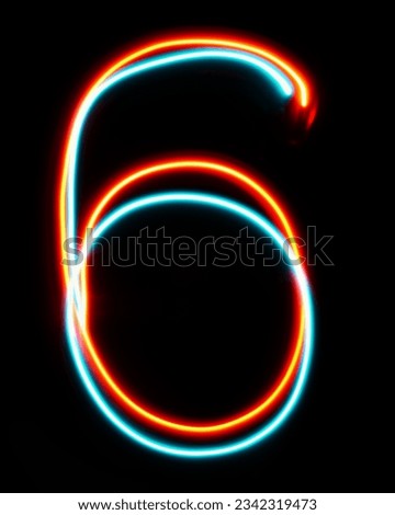 Number 6 of the alphabet made from neon sign. The blue red light image, long exposure with colored fairy lights, against a black background. Concept of design