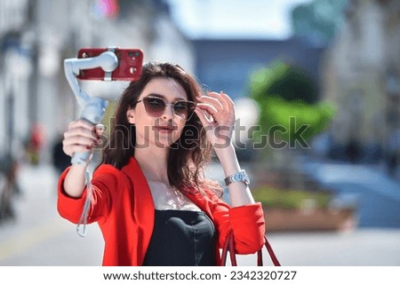 woman taking selfie on mobile phone with gimbal