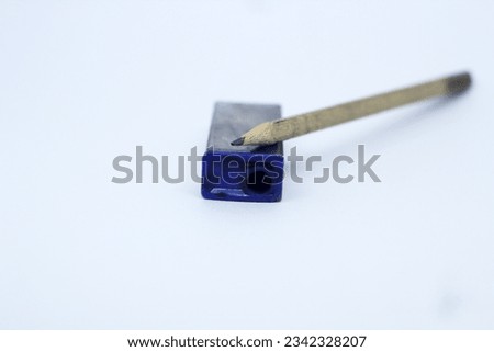 a photo of pencil and blue sharpener in the white isolated background.