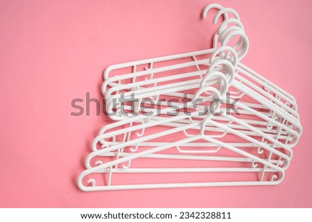 White hanger, top view on a pink background. Sale and shopping concept. Place for text.