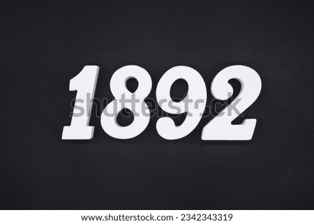 Black for the background. The number 1892 is made of white painted wood.