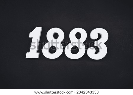 Black for the background. The number 1883 is made of white painted wood.