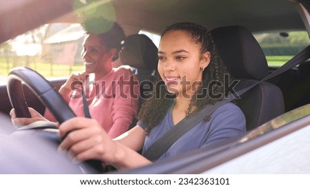 Teenage Girl In Car Having Driving Lesson From Female Instructor Or Parent Royalty-Free Stock Photo #2342363101