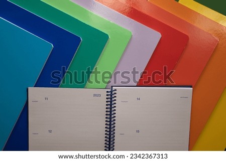 school or office supplies, colored notebooks with an open diary, with the year 2023 as a zenithal photo and space for text.
