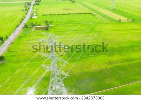 High-voltage electric poles in the top view and green fields.