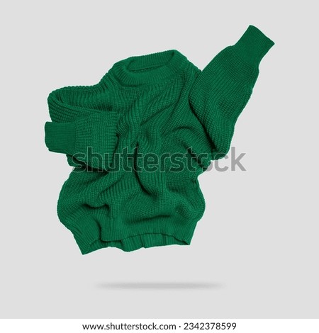 Green flying knitted sweater isolated on gray background. Warm cotton woolen knitted sweater, pullover, jacket. Cut out clothing object for design. Mockup. Clothes levitation concept Royalty-Free Stock Photo #2342378599