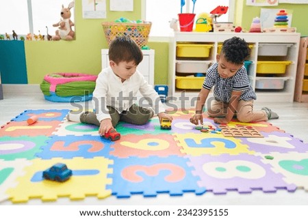 Adorable boys playing with car toy and maths game at kindergarten Royalty-Free Stock Photo #2342395155