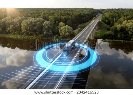 Autonomous semi-truck with a trailer, controlled by artificial intelligence, drives over a bridge over the river. Cargo delivery, transportation of the future. Artificial intelligence. Self driving.
 Royalty-Free Stock Photo #2342416523