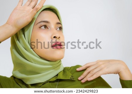 A close up of young beautiful Asian woman with hijab isolated on white background studio, muslim beauty skin care concept with green outfit.