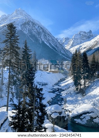 Beautiful winter landscape with ski houses next to the ski slope and forest.
