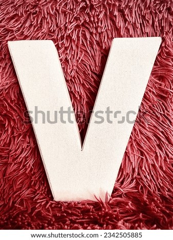 The letter V with a pink, fuzzy background.