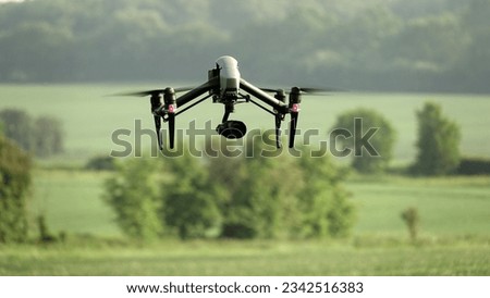 A drone for Insecticide injection flying over agriculture field during summer with trees background