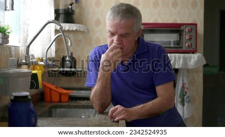 Drunk senior struggling with alcoholism leaning on kitchen sink at home, unhealthy behavior lifestyle in old age. Substance abuse concept Royalty-Free Stock Photo #2342524935