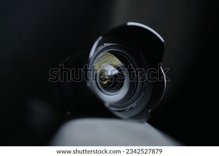 The lens of a camera isolated on the dark blurred background