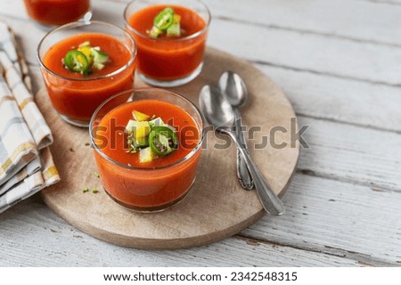 Cold tomato soups on white wooden table ready to eat; Spanish vegetable gazpacho in glass cups Royalty-Free Stock Photo #2342548315