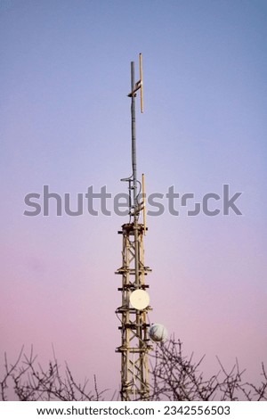 A vertical shot of a telecommunication tower, an antenna of a basic radiotelephone in the golden hours Royalty-Free Stock Photo #2342556503