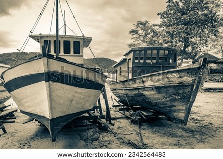 Black and white picture of old boats ships and boats for restoration in Abraao beach Ilha Grande Angra dos Reis Rio de Janeiro Brazil.