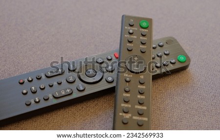 Two remotes for multimedia, on a gray background. Consumer electronics for controlling TV and players.