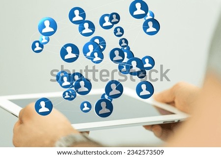 A closeup of the person's hands holding a tablet with floating account icons.
