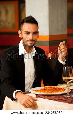 Young Man eating pizza in restaurant