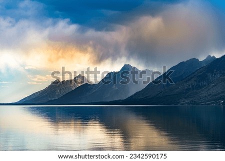 The Grand Teton National Park hills reflected in the water below at a sunset in Wyoming, United States Royalty-Free Stock Photo #2342590175