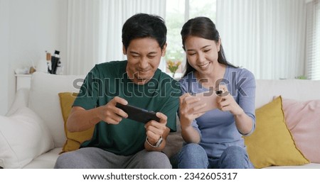 Young adult asia cute sweet couple enjoy playing sport match game online in esport race lover at home sofa couch. Two Gen Z people man and woman gamer happy relax smile laugh joy fun video gaming app. Royalty-Free Stock Photo #2342605317
