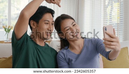 Asia people young couple relax leisure good easy time at cozy sofa home enjoy fun play phone trending filter effect selfie challenge in social media app  reel  viral video story photo shoot