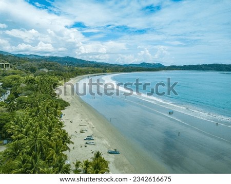Playa Samara, Guanacaste, Costa Rica - Drone shot with Beautiful Aerial view over the long white sand Samara Beach and green Palm Trees on the Pacific Coast of the Nicoya Peninsula