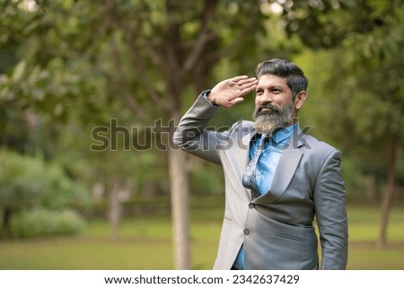 Indian man in suit and saluting at park Royalty-Free Stock Photo #2342637429