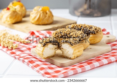 choux Pastry with chocolate and peanut topping and vanilla fla filling. with copy space. perfect for recipe, article, catalogue, commercial, or any cooking contents. 
